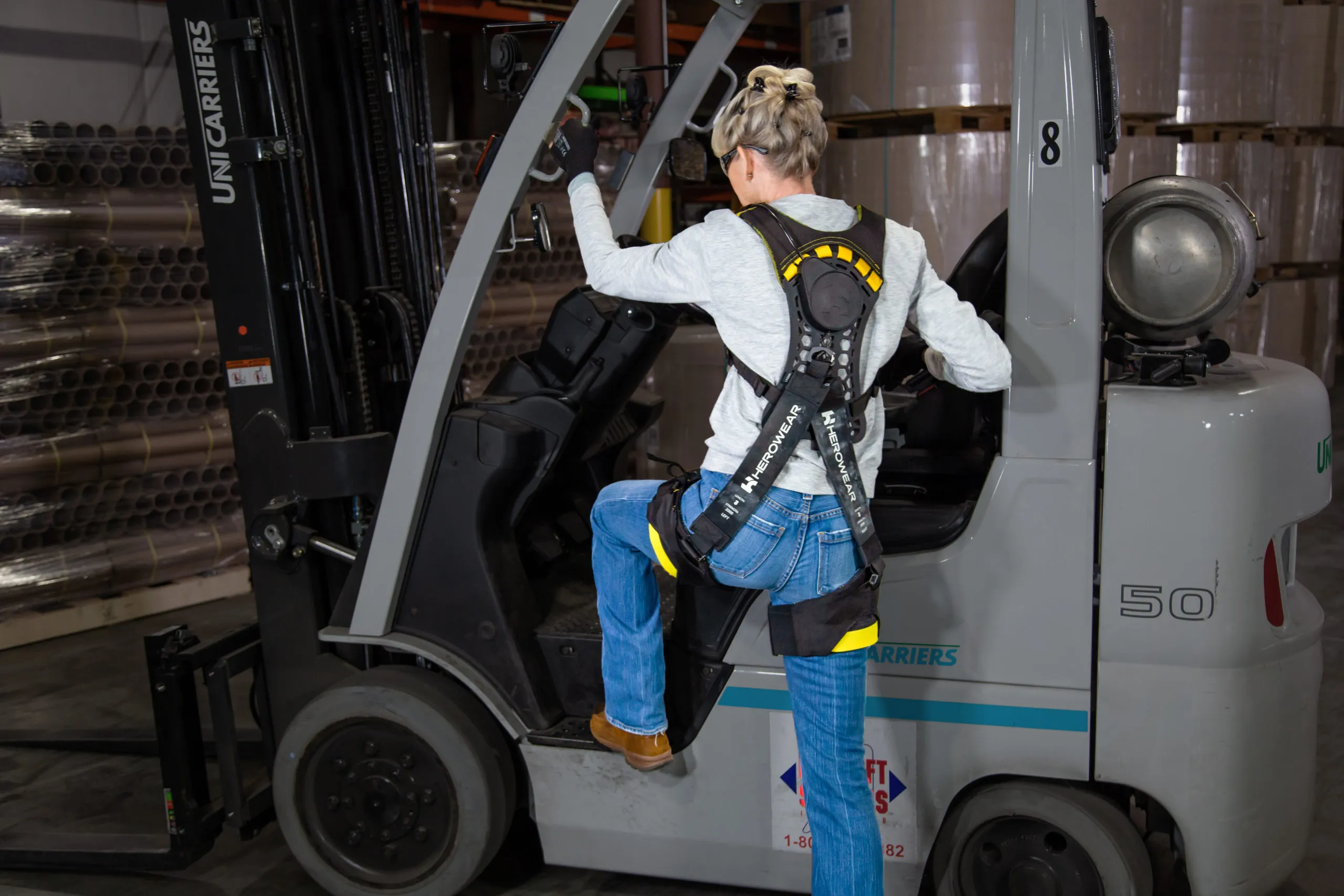A worker wearing the Apex 2 stepping up into a forklift